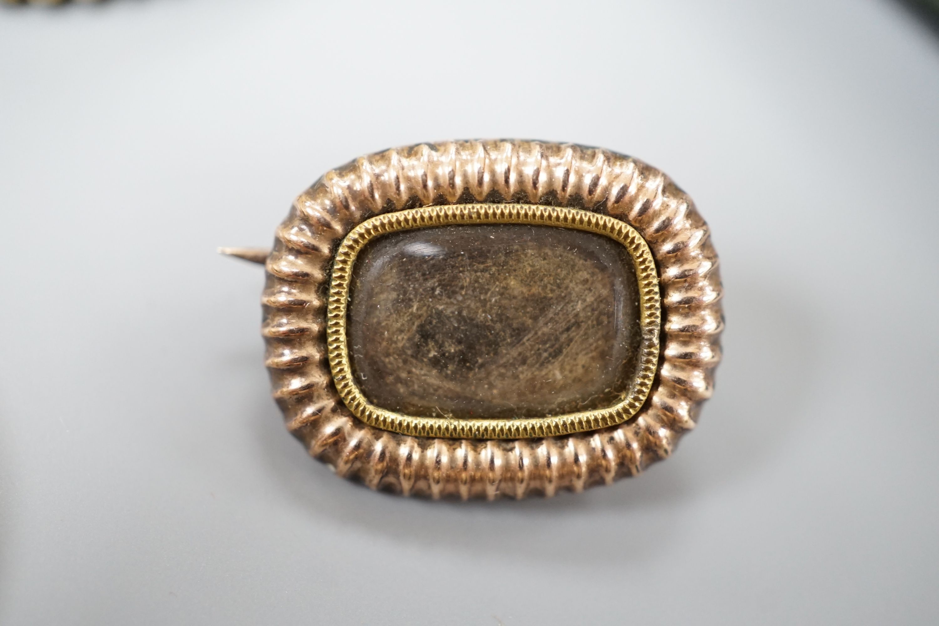 A Victorian yellow metal and cabochon garnet set circular brooch, 31mm, gross 9.3 grams, a stick pin with yellow metal and hardstone cameo set terminal, a mounted Indian miniature, a mounted cameo shell brooch and a Vict